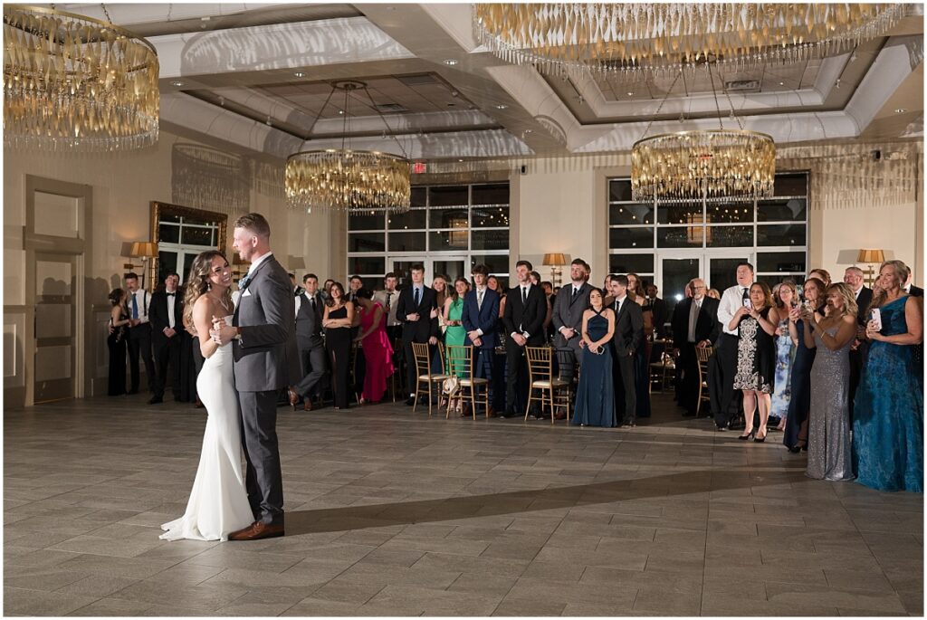 Bride and Groom dancing while their family is looking at them at Stone House at Stirling Ridge 