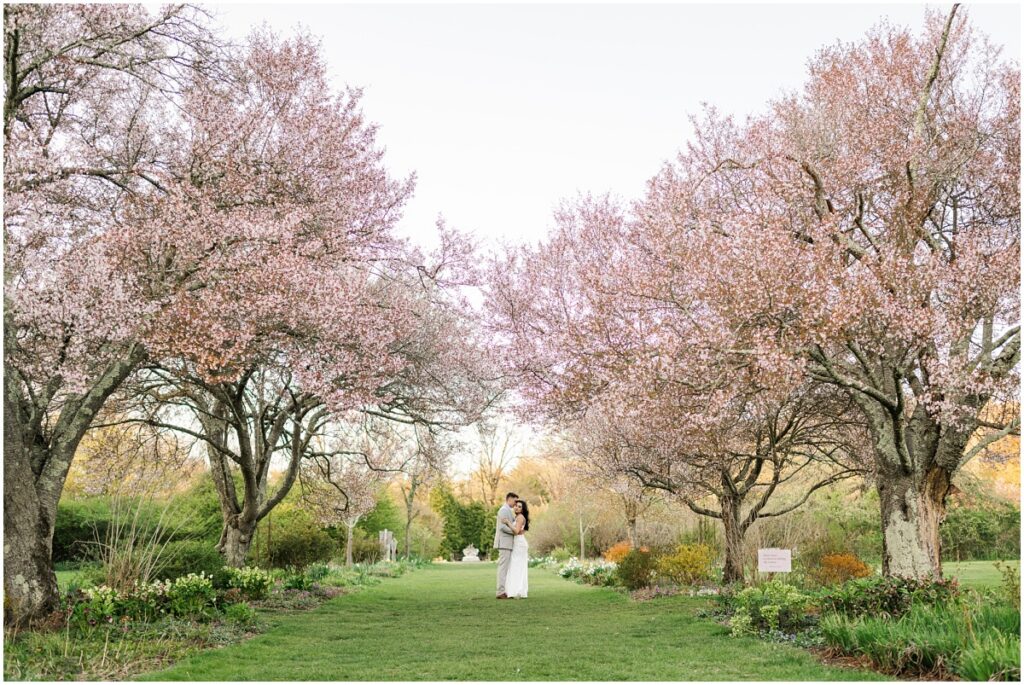 a couple posing for pictures at the Skyland's Manor Crabapple Allée