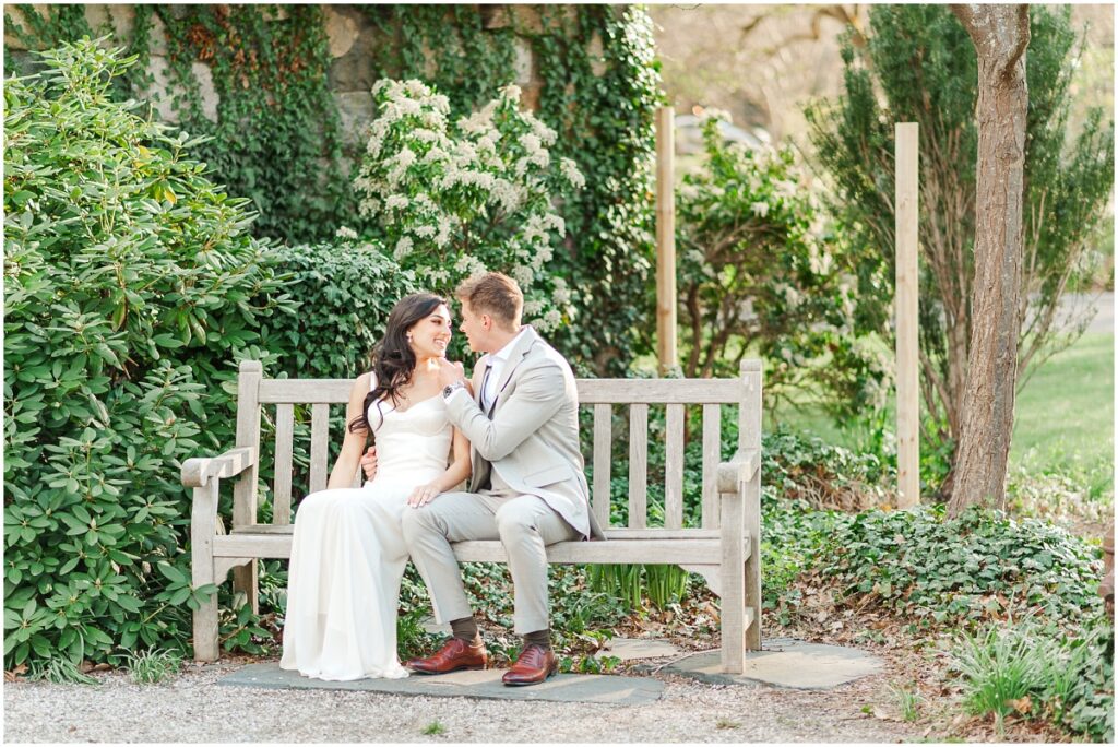couple laughing on a bench while posing for photos at the Skylands Manor, NJ